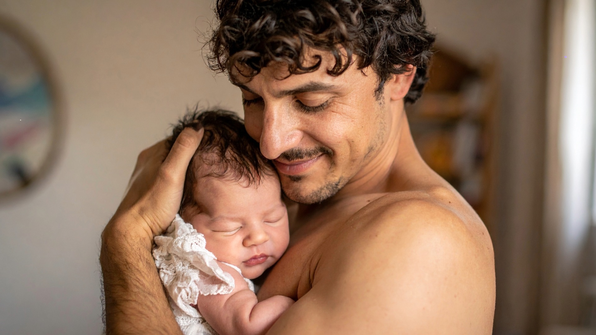 Father creadling newborn baby in his arms