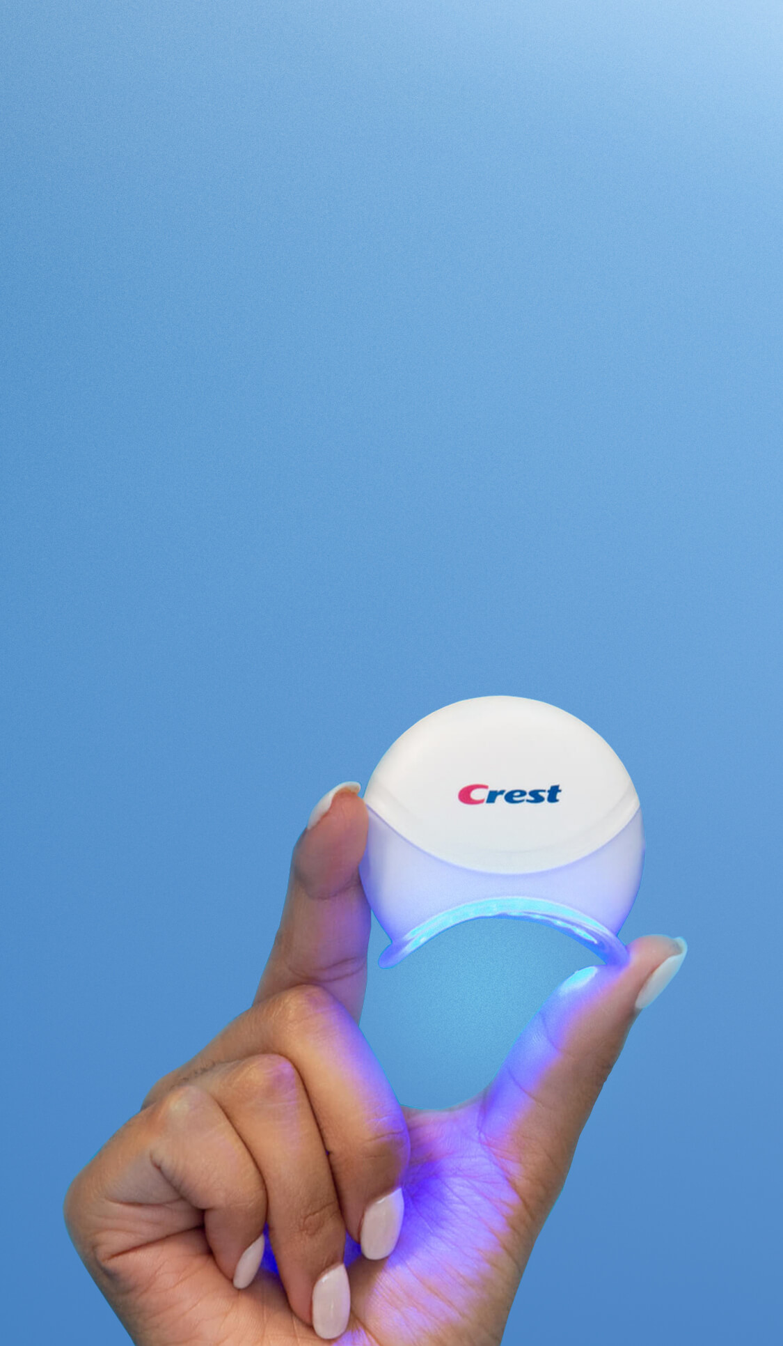 Hand holding Crest Blue Light with blue background | Crest White Smile