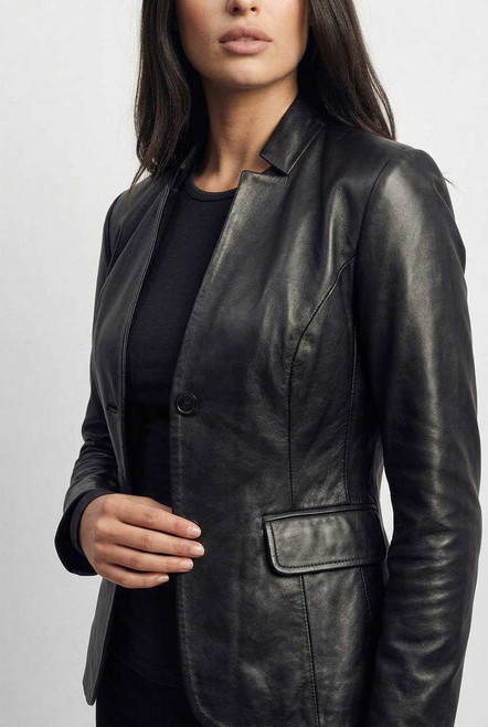 Close-up of premium leather texture, stitching, and lapel detail on blazer jacket