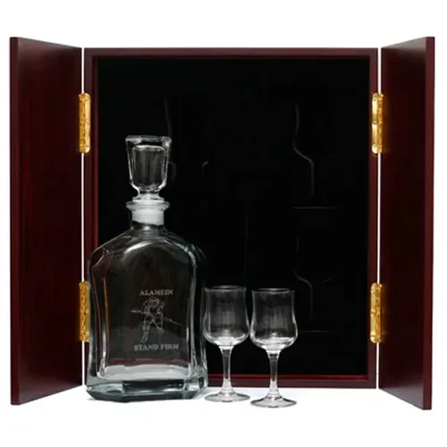 Alamein Company Decanter & Glasses in Display Case This (Alamein Company) Decanter in Display Case with Glasses, is the perfect gift, order it now from Military Shop. the beautiful two door timber finish display case with RMC crest handles measures 32