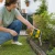 Mujer aplicando repelente granulado Nocan para perros y gatos en el jardín
