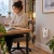 Mujer trabajando en casa con mini calefactor cerámico enchufable Bardei calentando la zona de trabajo