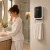 Baño moderno con calefactor toallero Supra Berenice, toalla colgada y persona en pijama