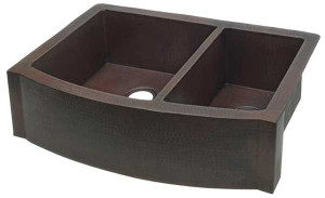 Rounded front farmhouse kitchen sink with 60/40 split bowls in hammered copper