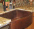 Rounded front farmhouse copper kitchen sink.