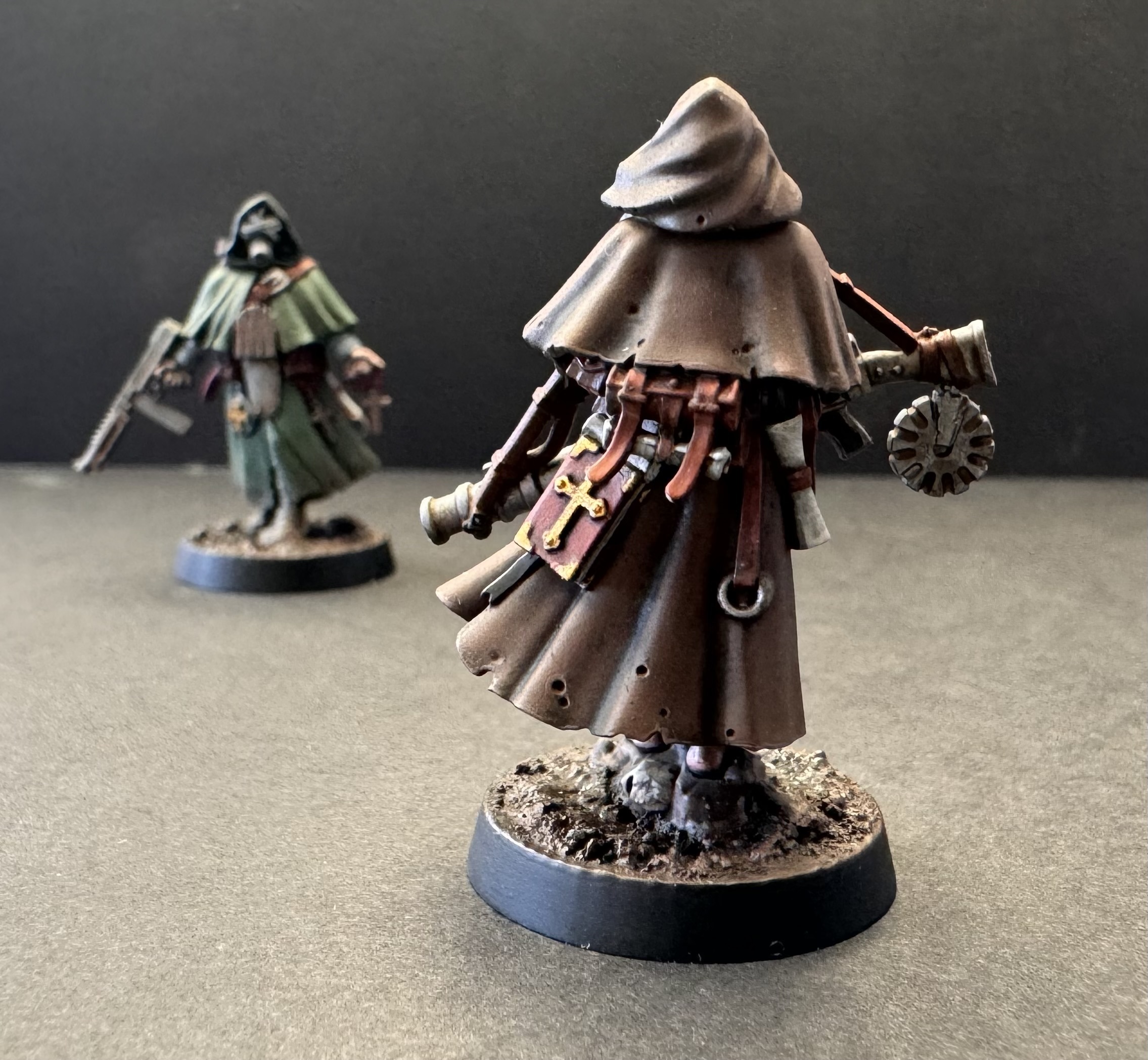 Brown robe - back pose showing leather backpack and book