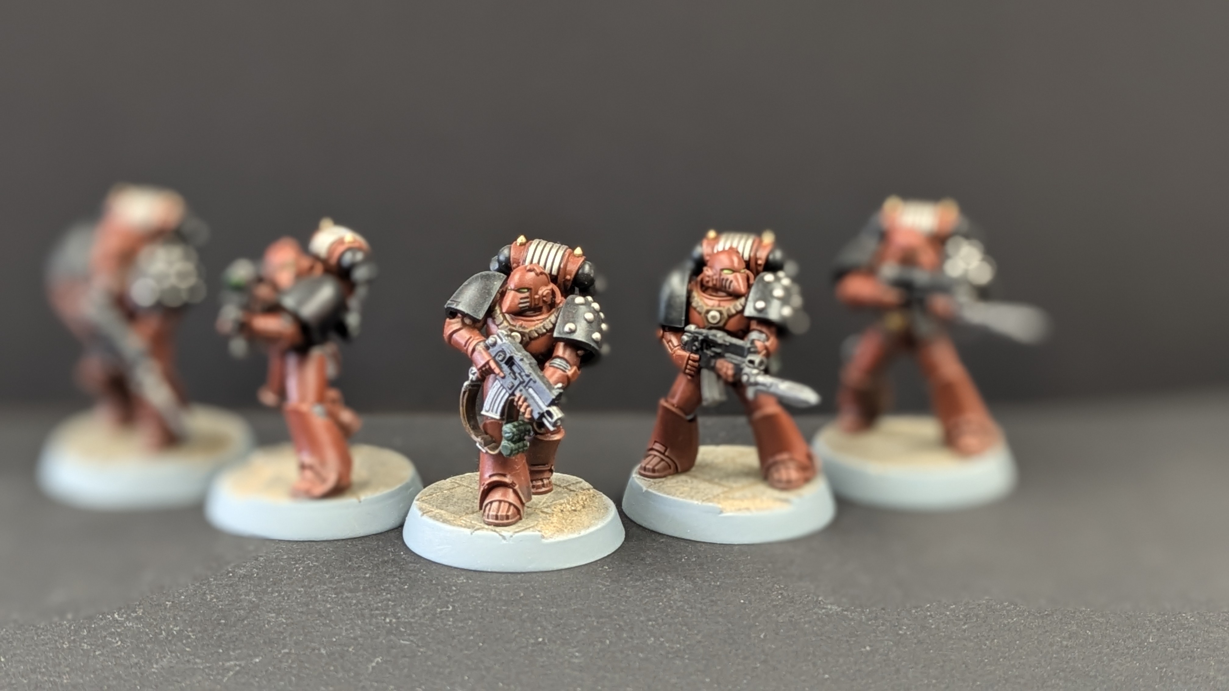 Word Bearers Space Marine close-up with shallow depth of field showing terracotta armour detail and green eye lenses