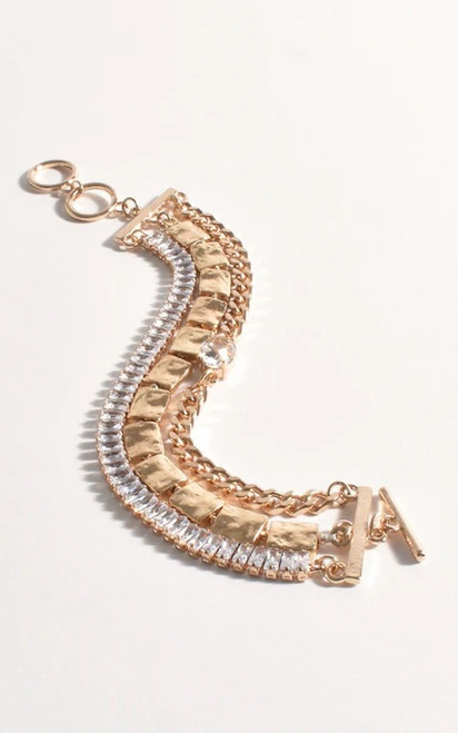 Adorn your wrist with the captivating allure of our Golden Radiance Cuff Bracelet. This multi-layered masterpiece combines a rich tapestry of textures and sparkle, featuring rows of brilliant diamantes, hammered gold-toned segments, and delicate chain detailing. Designed to create a luxurious statement, this bracelet is a testament to sophisticated craftsmanship, ensuring you shine brightly at any event. Elevate your style with this dazzling and versatile accessory.

This bracelet features:

Multi Strand cuff
Mixed jewel strands
Toggle closure
Colour: Gold

Material: Crystal and Plated Metal

Measurements: 16cm plus Extension