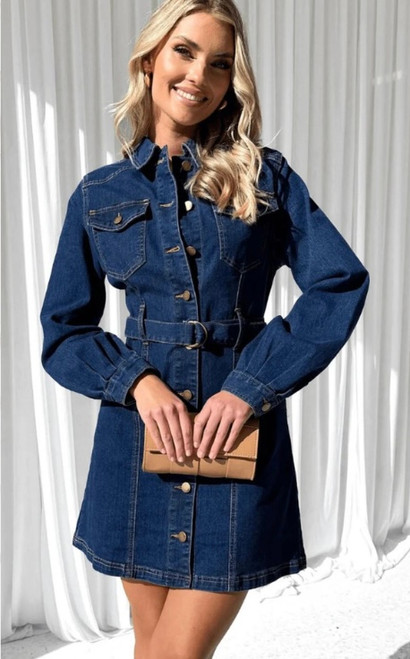 Model wearing the Georgia denim dress, a long sleeve button-down belted denim mini dress styled with heels