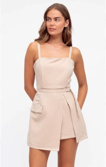 Model wearing the Harper beige playsuit with a square neckline, thin shoulder straps, belted waist and wrap-style skirt overlay.