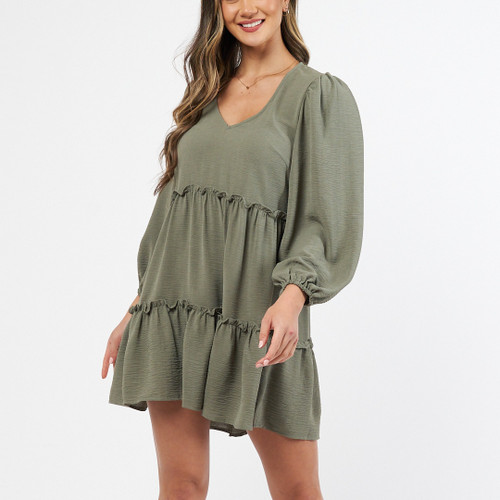 This cute smock dress is perfect for any occasion! It's so easy to wear and can be dressed up with tan ankle boots and a tan belt or worn with white sneakers or sandals for a more casual look. It's also a great dress that can be worn with a growing baby bump throughout all the seasons!

This dress features:

V-neckline
Tiered design
A touch longer at the back than the front
Long sleaves with elastic cuffs
Not lined
No stretch
Colour: Khaki

Fabric: Cotton/Spandex blend

This dress is true to size.
Suburban Closet
