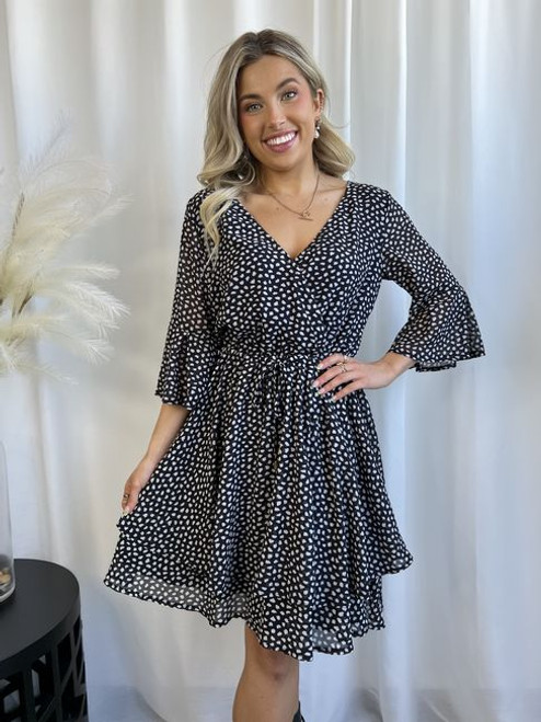 Our super cute and floaty Kathleen Dress is one you can wear to brunch, lunch or a dinner date. You'll have so much fun and confidence in this spotted little dress. Pair with wedges by day and heels at night and you're ready to go whatever the occasion.

This dress features:

V neckline
Wrap style with clasp
3/4 sleeves with frill 
Ruffled hemline
Elasticised waist 
Functional drawstring waist tie
Lined
Colour: Black with White Spotted Pattern

Fabric: 100% Polyester, Lining 100% Rayon

Size Guide: True to size.
Suburban Closet