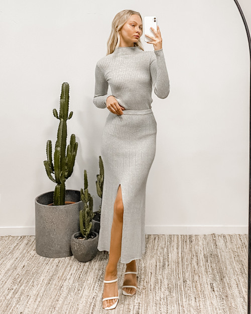 Our Nadine Ribbed Knit Skirt is a beautiful, flowy, midi length style. Easy to throw on for a casual day trip or dress it up for a night out with heels and a cute clutch. This skirt pairs perfectly with our Nadine Ribbed Knit Top! 

This skirt features:

High waist
Front leg split
Midi length
Ribbed design 
Has stretch
Colour: Grey

Fabric: 100% Cotton

Size Guide: S (6-8); M (10-12); L (12-14)
Suburban Closet