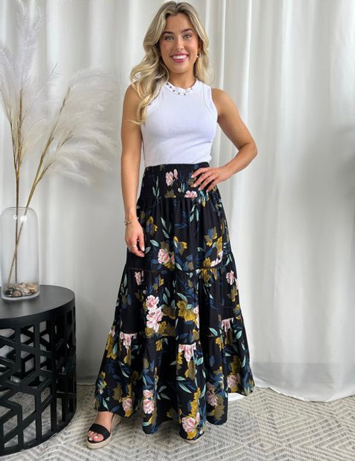 Our stunning Sabrina Maxi Skirt will have you feeling super pretty with its flowy, tiered style, stunning floral print and ladder lace detail. It is sure to become a "go-to" staple in every boho babe's wardrobe. Pair with a white tee or cami and our cute Phyllis Macrame Bucket Bag for the perfect boho look. 

This maxi skirt features:

Tiered design
Thick shirred waist
Ladder lace separating each tier
Ruffled hemline
Maxi length
Colour: Black with floral pattern

Fabric: 100% Rayon

Size Guide: True to size. Order your usual size. Model is 164cm tall and wearing a size 8.
