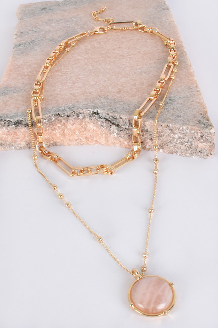 A gorgeous statement piece, our Neisha Layered Stone Necklace is perfect to wear for any occasion. Featuring a double layer and a framed stone pink pendant, this necklace is sure to impress.

This necklace features:

Two layered necklace
Parrot clip closure
Framed stone pendant
Long, dainty drop necklace with gold ball details
Short, chunky link necklace
Colour: Pink and Gold

Material: Stone & Plated Metal

Length: 40cm plus extension