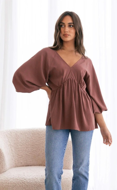Our super soft Tassie Top would make a cute addition to your wardrobe. Featuring 3/4 balloon sleeves and a relaxed baby doll fit, this floaty top offers both comfort and elegance. Pair this top with our Wet Look Skinny Jeans and accessorise with some gold jewellery and you're good to go.

This top features:

V neckline front and back
3/4 Balloon sleeves with elasticised cuffs
Baby doll style
Soft fabric
Relaxed style
Colour: Chocolate

Fabric: 100% Tencel

Size Guide: True to size. Stick with your ususal size, but it is a relaxed style. Model is wearing a size S