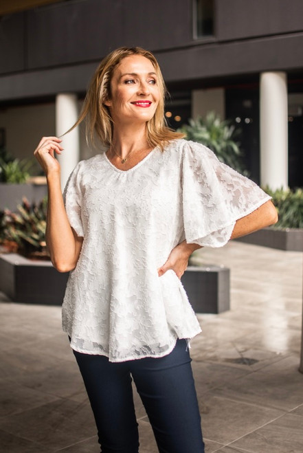 So chic, yet so sweet, our Tillie Chiffon Top is going to be your new fave this summer. This cotton blend beauty features a flowy design and flutter sleeves. Dress up with a pair of our Wet Look Skinny Jeans or wear it casually with your fave denim. 

This top features:

V-neckline
Flutter sleeves
Textured chiffon fabric
Curved hemline
Longer length at the back
Lined
Relaxed fit
Colour: White

Fabric: 85% Cotton, 15% Polyester

Size Guide: True to size. Order your usual size.