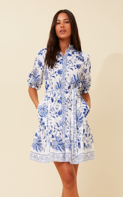 Bring effortless elegance to your wardrobe with our Elara Floral Dress, a timeless dress in a fresh blue and white floral print. Designed with a button-down front, high neckline that can be unbuttoned to give a relaxed V-neckline and soft puff sleeves, this dress blends classic charm with modern femininity. The adjustable tie waist flatters your figure, while the tiered skirt adds movement and a playful touch.This stunner is perfect for long lunches, coastal getaways or everyday chic. And yes, it has pockets — making it as practical as it is stylish.

This dress features:

High neckline with buttons
Button up front
Functional side pockets
1/2 sleeves with elastic cuffs
Adjustable waist tie of same fabric
Frilled hemline
Unlined
Colour: White with Blue Floral Print

Fabric: 100% Polyester

Size Guide: True to size. Model is 173cm tall and wears a Size 8.