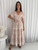 Step into style with our exquisite Kathleen Maxi Dress. Designed for the modern romantic, this beautiful dress features a flattering V-neckline, short flutter sleeves and adjustable drawstring waist ensure a comfortable and customised fit that accentuates your silhouette. This maxi dress boasts a graceful tiered skirt, beautifully detailed with charming white ric rac detailing. With convenient side pockets, it blends practicality with undeniable charm. Perfect for garden parties, beachside strolls or casual summer events, this dress will be your go-to for an effortlessly chic look. Pair it with sandals for a relaxed vibe or dress it up with wedges and accessories.

This dress features:

V neckline
Button up bust
Functional side pockets
Short sleeves sleeves with pic rac detailing
Elasticised waist with functional drawstring
Tiered skirt with ric rac detailing
Ruffled hemline 
Unlined
Maxi length
Colour: Natural with White Print

Fabric: 100% Rayon

Size Guide: True to size. Model is wearing size 8.