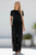 Larissa Linen Blend Wide Leg Pants in black with side stripe detail, wide leg silhouette, and elastic drawstring waistband styled with a white tank top and sandals.