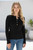 Black Maxine Ribbed Knit Top with gold button henley neckline and fitted ribbed fabric styled with high-rise blue jeans.