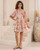 Model wearing orange and pink floral Annabelle babydoll mini dress with button front, pockets and flowy sleeves
