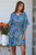 Model wearing the Electric Safari Kaftan cover-up featuring a vibrant zebra print pattern with a gathered elastic waist and blue tassel details.