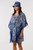 Model wearing the Into The Deep matching resort wear set. The set features a cotton V-neck kaftan cover-up and a matching unstructured bucket hat, both showcasing a rich indigo blue and white botanical leaf pattern with a decorative blue chevron border.