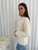 Wrap yourself in cosy elegance with our Aspen Wool Blend Knit in a timeless ivory hue. This soft, plush knit features a beautifully textured cable pattern that adds both warmth and style to your winter wardrobe. With its relaxed fit, ribbed hem and cuffs and classic crew neckline, this sweater is perfect for layering or wearing solo for an effortlessly chic look. Pair it with your favourite denim for a classic winter vibe or dress it up with a midi skirt or our Wet Look Skinny Jeans and boots.

This knit features:

Round ribbed neckline
Ribbed cuffs and hem
Cable knit design
Wool blend
Has some stretch
Soft feel
Colour: Ivory

Fabric: 65% Acrylic, 35% Wool

Size Guide: S/M will fit sizes 8-12, M/L will fit sizes 14-16. Model is wearing a size S/M and is 172cm tall.