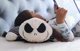 Jack Skellington Pillow Pet with a little girl lying on it reading a book.