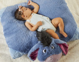 A baby sleeping on an Eeyore Jumboz Pillow Pet