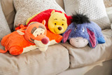 Eeyore, Winnie the Pooh, and Tigger Pillow Pets displayed together on a couch.