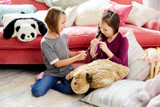 Lifestyle Image of girls playing with the Snuggly Puppy Pillow Pet.