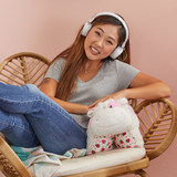 Girl relaxing with the Strawberry Cow Pillow Pet while listening to music.