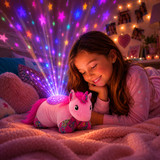 Little girl cuddling the Colorful Pink Unicorn Sleeptime Lite while looking at the colorful stars projected onto the ceiling.