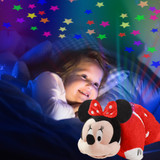 Little girl cuddling the Minnie Mouse Sleeptime Lite while looking up at the colorful stars projected onto the ceiling.