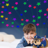 Little boy with the Chase Sleeptime Lite smiling and looking up at the colorful stars projected onto the ceiling.