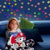 Child cuddling the Marshall Sleeptime Lite while looking up at the colorful stars projected onto the ceiling.