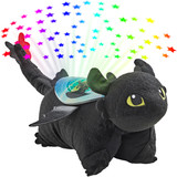 Toothless Sleeptime Lite folded in plush character form projecting colorful stars onto the ceiling, featuring Toothless's black plush body, bright green eyes, pointed ears, wings, and signature tail fins.