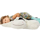 Little girl lying on the Cozy Cow Jumbo Pillow Pet.