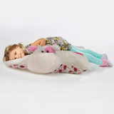 Little girl lying on the Sweet Scented Strawberry Cow Jumbo Pillow Pet unfolded in pillow form.