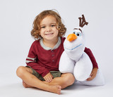 Little boy smiling hugging the Olaf Pillow Pet.