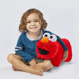 Little boy smiling hugging the Elmo Pillow Pet.