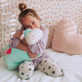 Little girl hugging the Love Cow Pillow Pet Puff while smiling.