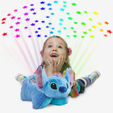 Little girl beside the Stitch Sleeptime Lite while it projects colorful rainbow stars onto the ceiling.