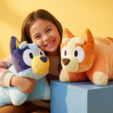 Lifestyle image of a little girl hugging a Bluey and a Bingo Pillow Pet
