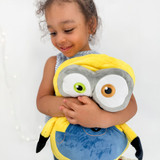 Little girl hugging Bob the Minion Pillow Pet.