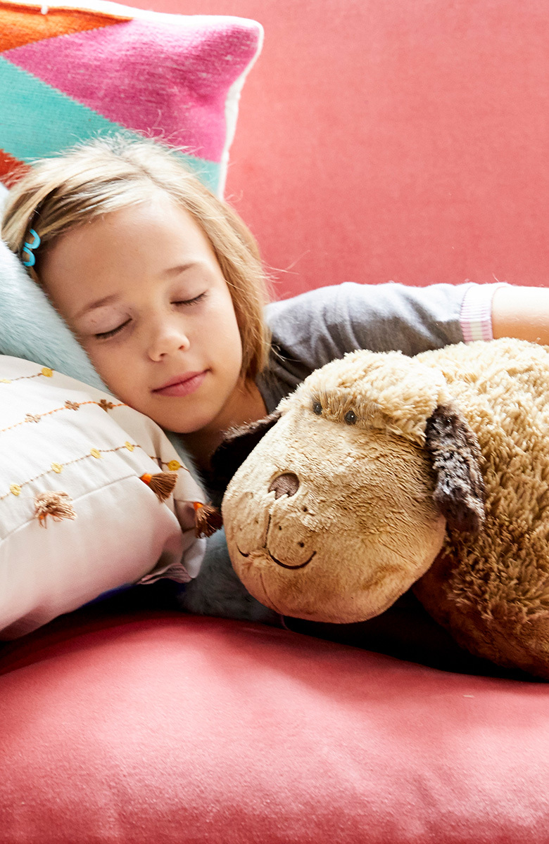 Young girl snuggling with Pillow Pet