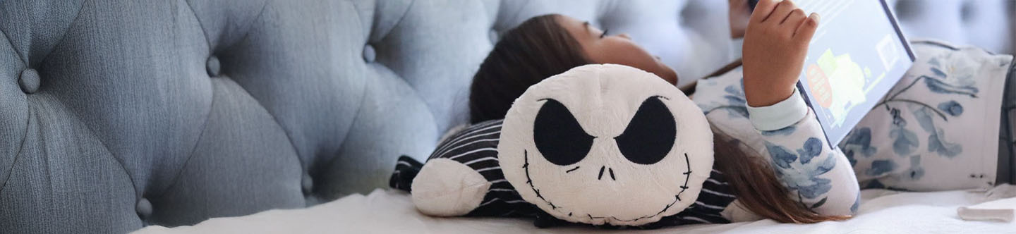 The Halloween Shop banner shows a little Girl lying on a cute Jack Skellington Pillow Pet reading a book.