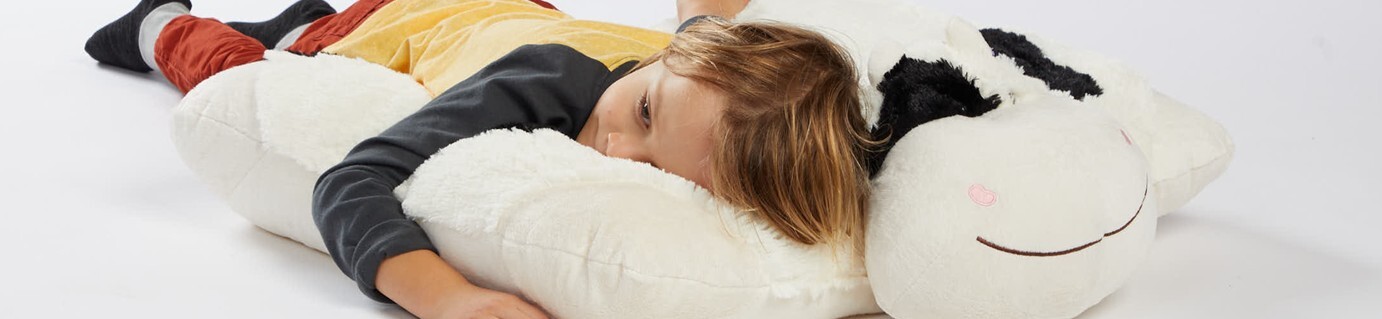Little boy snuggling and sleeping on a huge jumbo sized Pillow Pet!